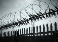 security-barbed-razor-wire-and-spiked-fencing-against-sky-EHBGKN.jpg