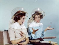 1960s-2-women-sit-under-beauty-salon-hair-dryers-clear-helmets-hoods-AAMJXW.jpg