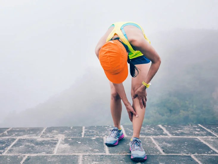 woman-trail-runner-hold-her-sports-injured-legs-at-the-top-of-mountain-732x549-thumbnail-732x549.jpg