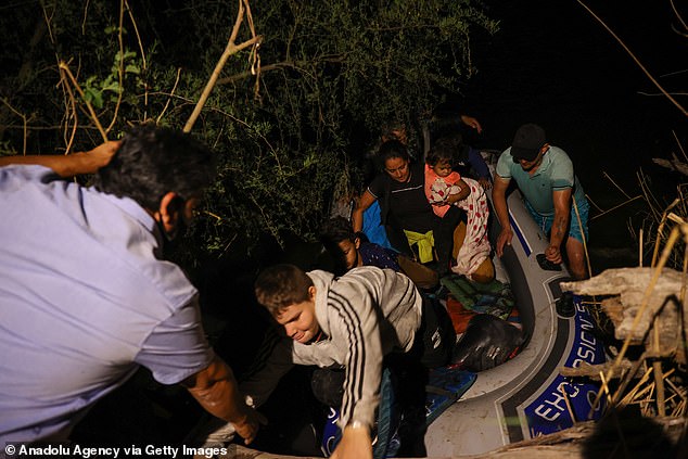 41496404-0-Migrants_are_seen_getting_out_of_a_boat_that_they_took_to_traver-a-3_1617891948770.jpg