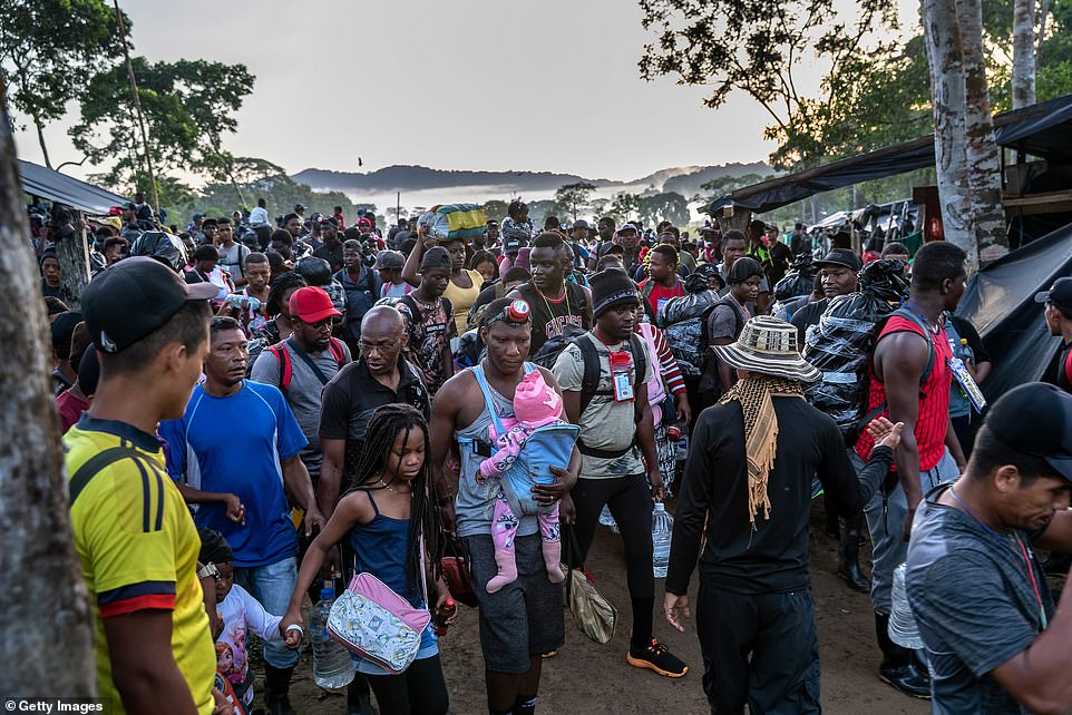 48925625-10072629-Migrants_most_from_Haiti_depart_a_base_camp_towards_the_jungle_i-a-65_1633704621459.jpg