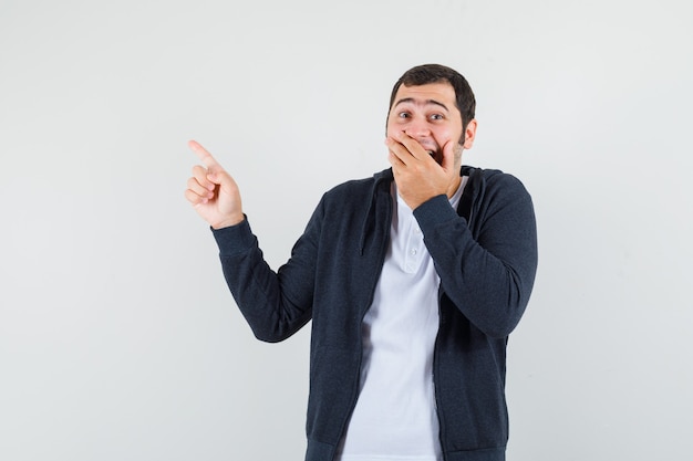 young-male-pointing-up-while-laughing-t-shirt-jacket-looking-happy-front-view_176474-45278.jpg