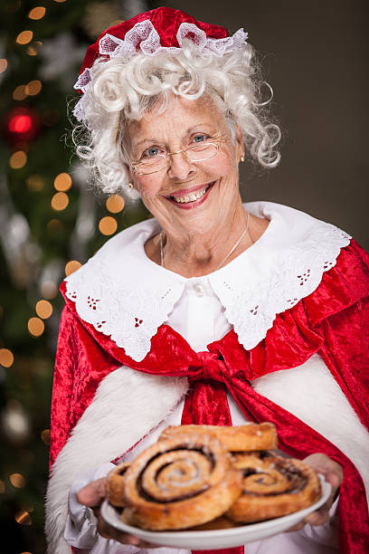 ms-claus-with-plate-of-cinnamon-rolls-picture-id496378162