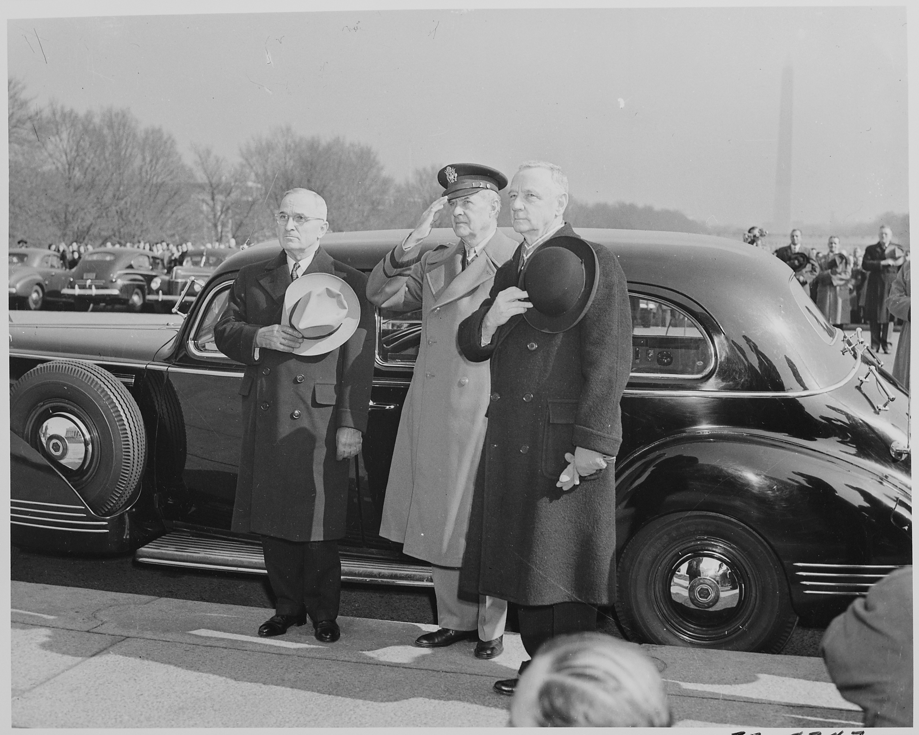 Photograph_of_President_Truman%2C_with_two_unidentified_men%2C_standing_beside_his_car_with_his_hat_over_his_heart..._-_NARA_-_199502.jpg