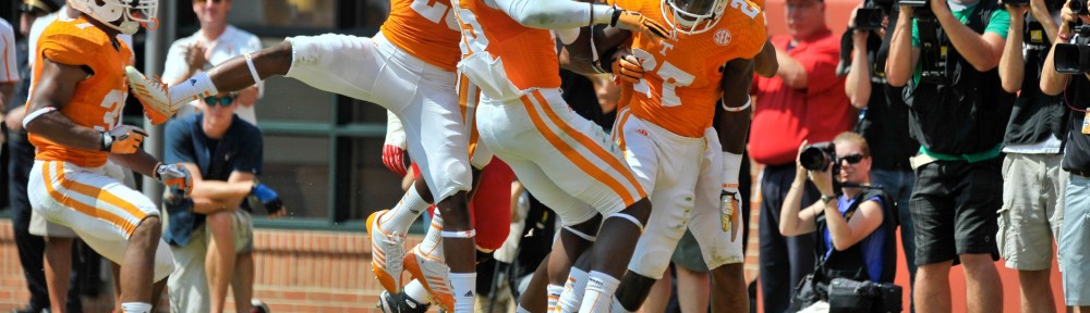 Caption: Sep 7, 2013; Knoxville, TN, USA; Tennessee Volunteers defensive back Justin Coleman (27) celebrates scoring a touchdown on an interception against Western Kentucky Hilltoppers quarterback Brandon Doughty (12) (not pictured) with teammate Tennessee linebacker A.J. Johnson (45) and Tennessee linebacker Dontavis Sapp (41) during the first half at Neyland Stadium. Mandatory Credit: Jim Brown-USA TODAY Sports